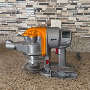 Dyson Corded Handheld Vacuum in Silver and Orange Accents